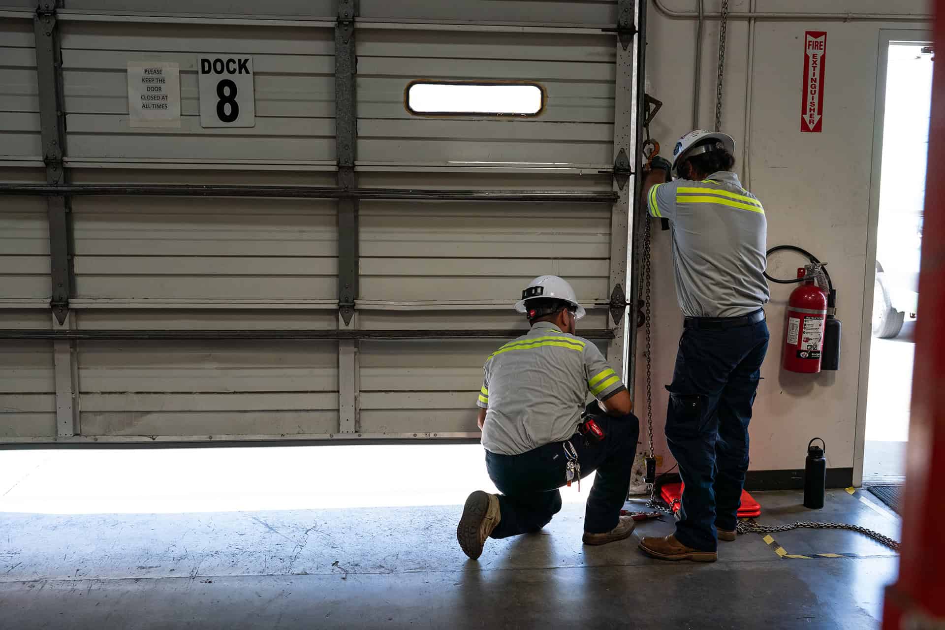 Garage door technicians closing a commercial door